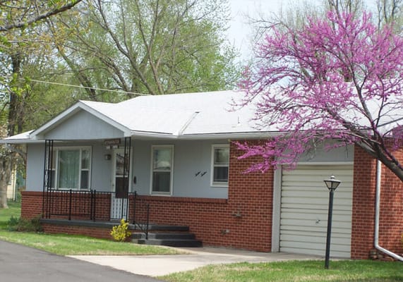 Exterior view of a small residential facility with trees