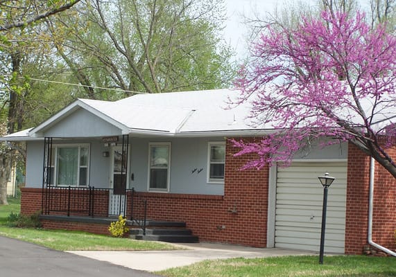 Exterior view of a small residential facility with trees