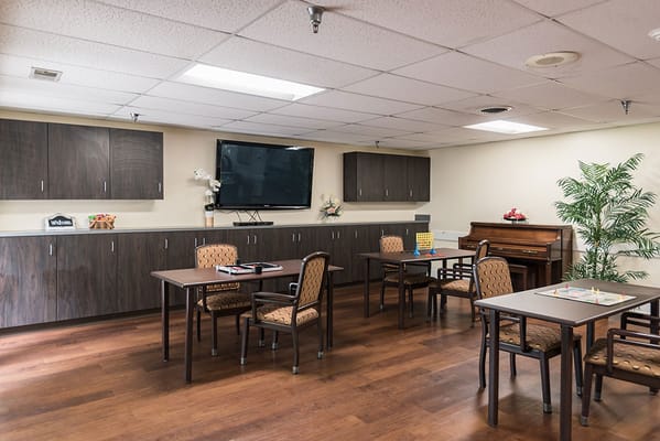 An interior common area with tables and a piano