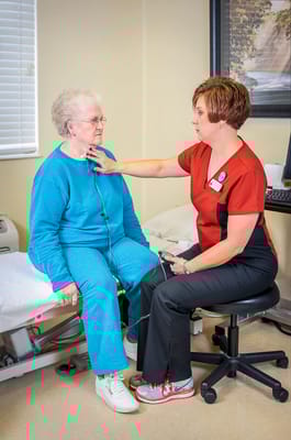 Nurse assisting a resident in a care room