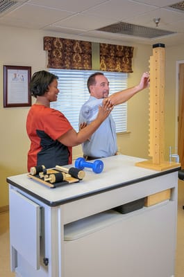 Therapist assisting a resident in a rehabilitation session