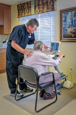Therapist assisting a resident with exercise equipment