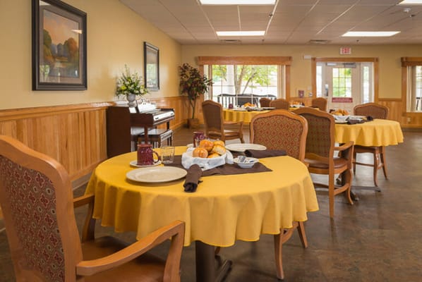 Dining room set up for a meal with yellow tablecloths