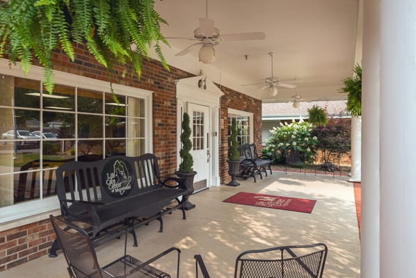 Outdoor seating area with rocking chairs and greenery