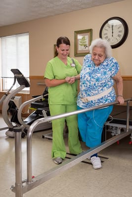 Caregiver assisting a resident in rehabilitation