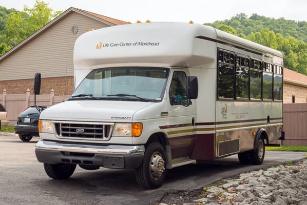 Facility shuttle van parked near the building