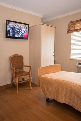 Comfortable resident room with a TV and chair