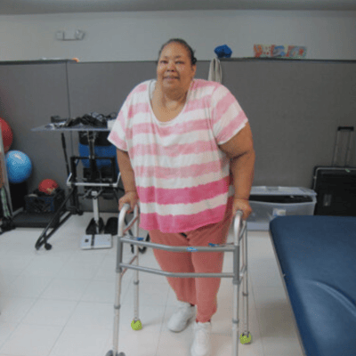 Resident using a walker in a therapy room