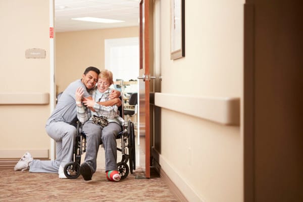 Staff member hugging a resident in a therapy room
