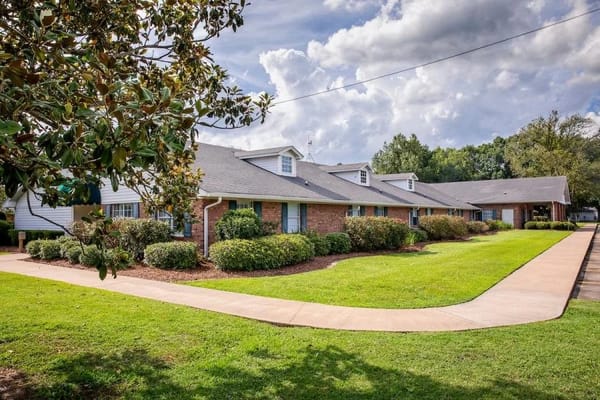 Exterior view of a senior living facility with landscaped garden
