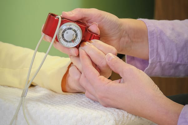 A caregiver checking a patient's reflexes during a consultation