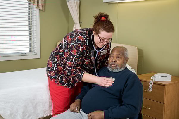 Nurse checking a resident's health in a room