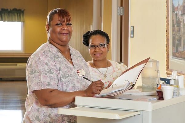 Two staff members smiling at a reception desk
