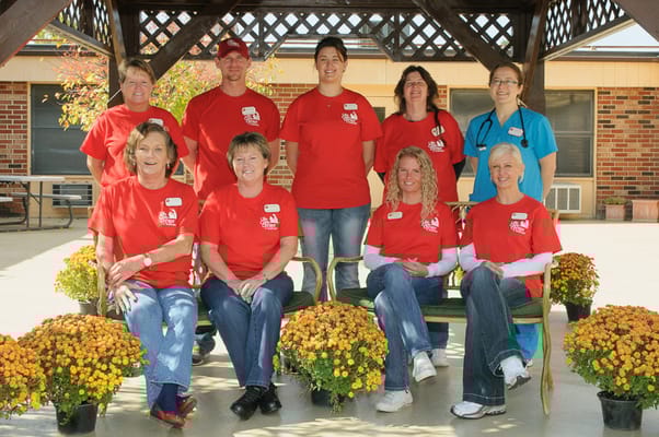 Staff members posing outdoors in matching red shirts