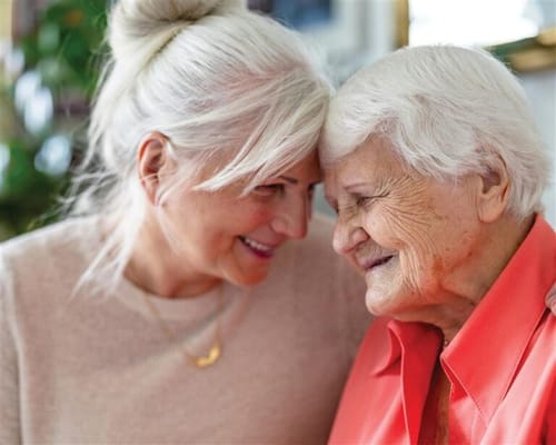 A senior resident smiling close to a staff member