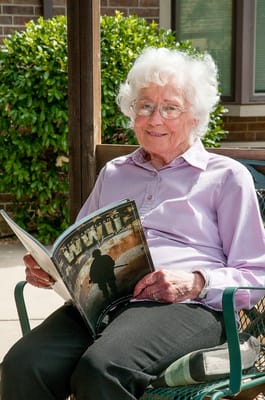 A resident enjoying reading outdoors in a garden area