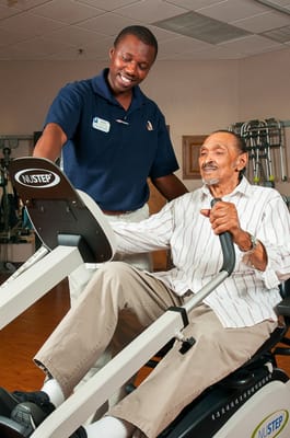 A staff member assisting a resident during exercise