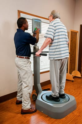 Staff assisting a resident with movement therapy equipment