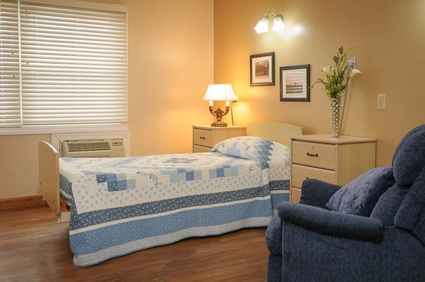 Cozy private resident room with a bed and chair