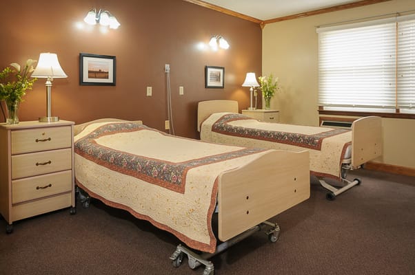 A cozy resident room with two beds and lamps