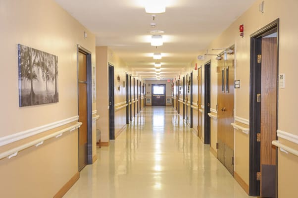 Well-lit corridor with resident rooms
