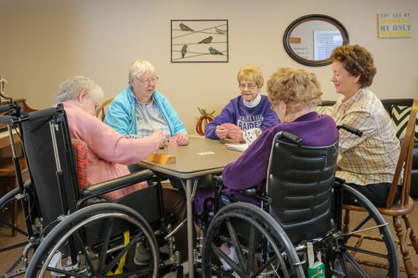 Residents engaged in a card game at a common table