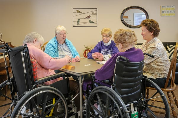 Residents engaged in a card game at a common table