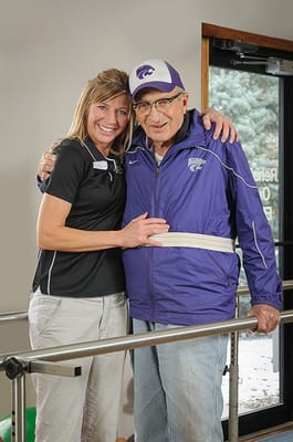 Staff member assisting a resident in a rehabilitation area