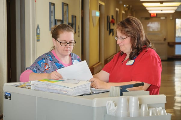 Staff members reviewing paperwork in a hallway