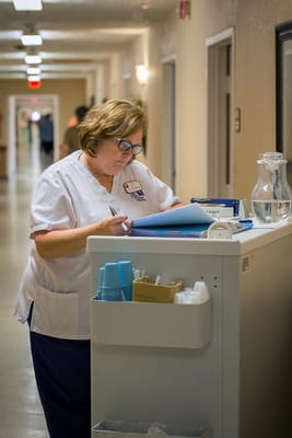 Staff member organizing paperwork in a hallway