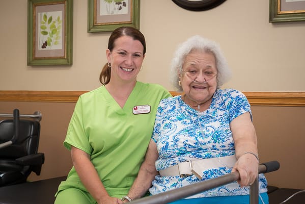 Staff member and resident posing together in a common area