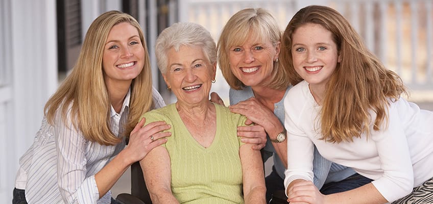Four women smiling together, showcasing connection and community.