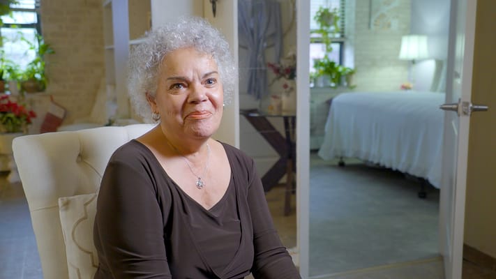 A resident smiling in a well-lit living area