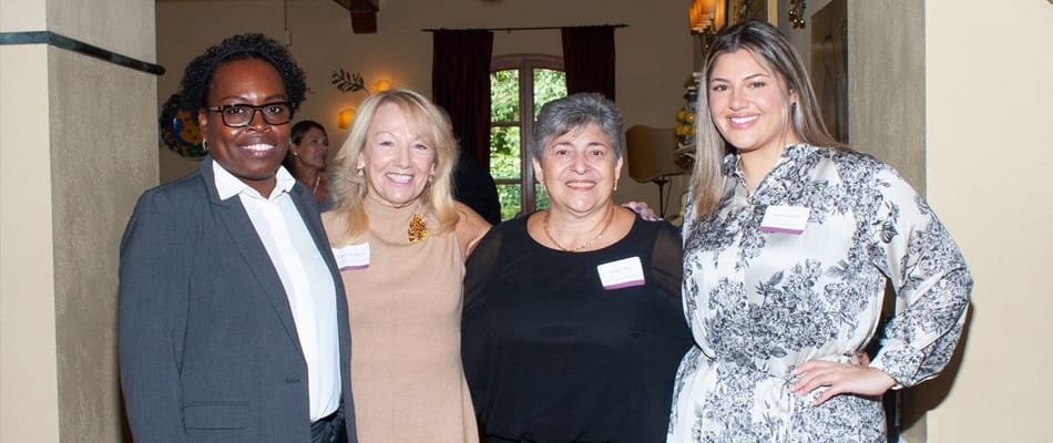 Four smiling staff members in a common area