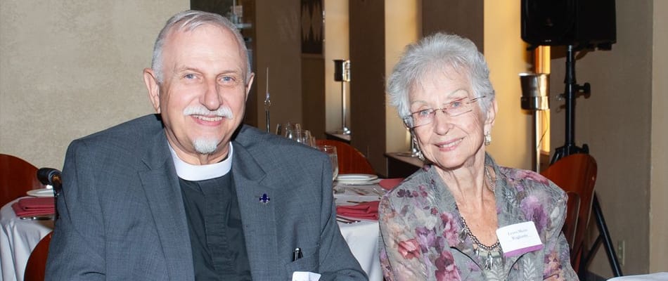 Two residents enjoying a meal together in a dining setting.