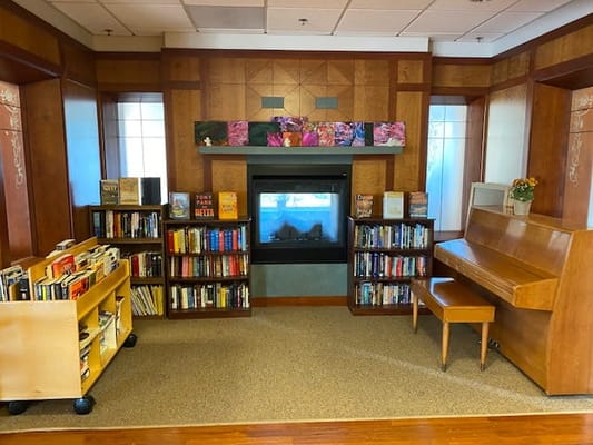 Interior of a cozy library area with books and a fireplace