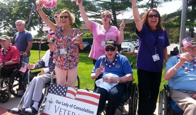 Residents celebrating with flags and signage outdoors