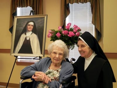 Residents posing for a photo with a bouquet of roses