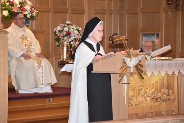 A nun reading from scripture during a service