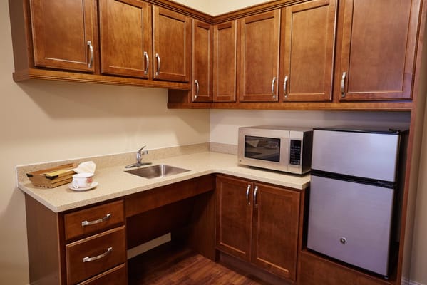 Modern kitchen area with wooden cabinets and appliances