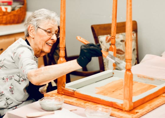 Resident painting furniture in a workshop activity
