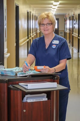Staff member interacting with paperwork in a hallway