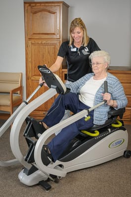 Resident engaged in exercise with staff assistance