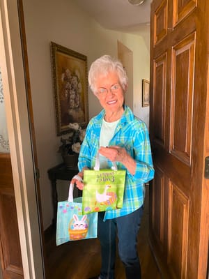 A resident holding gift bags in a welcoming entrance