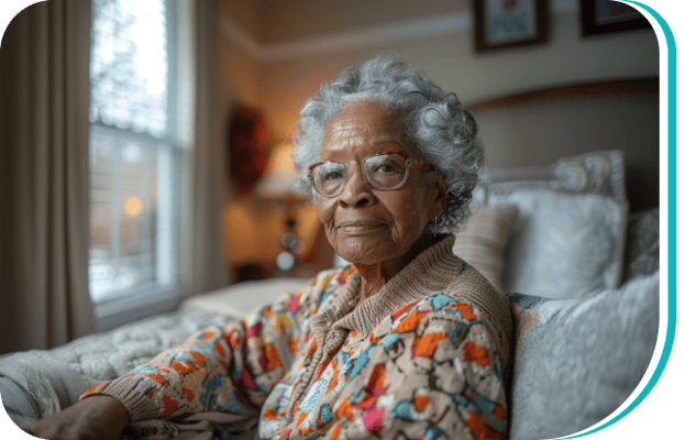 An elderly woman with glasses sitting in a well-lit room