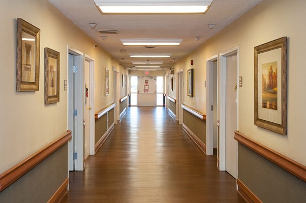 Well-lit hallway with framed artwork and doors