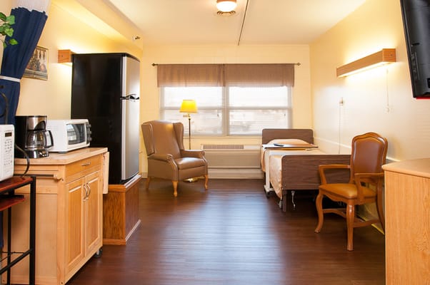 Cozy private resident room with a bed and chair