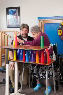 Resident and staff engaging in a colorful activity