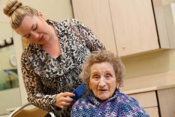 Stylist assisting an elderly woman with hair care