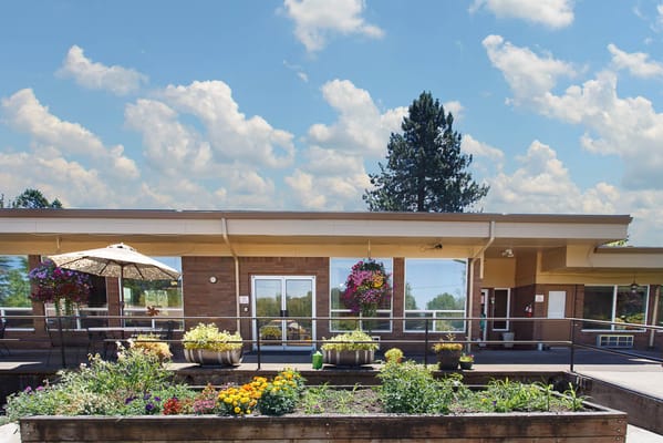 Exterior view of the facility with flower beds and seating area